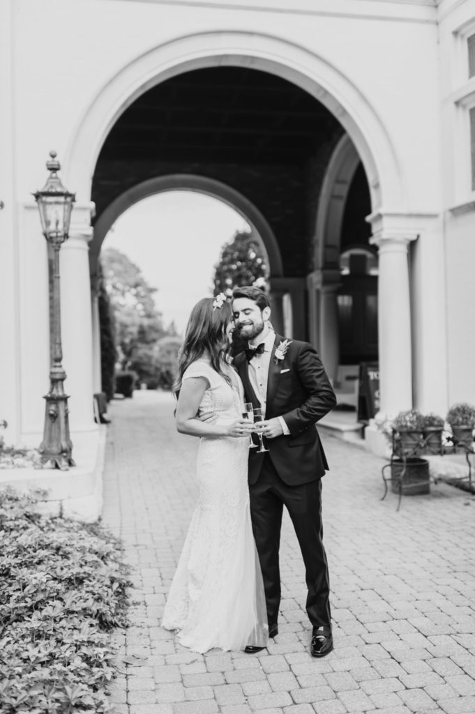 A timeless black and white photo captures a romantic moment between the bride and groom as they whisper sweet words to each other. L Hewitt Photography

