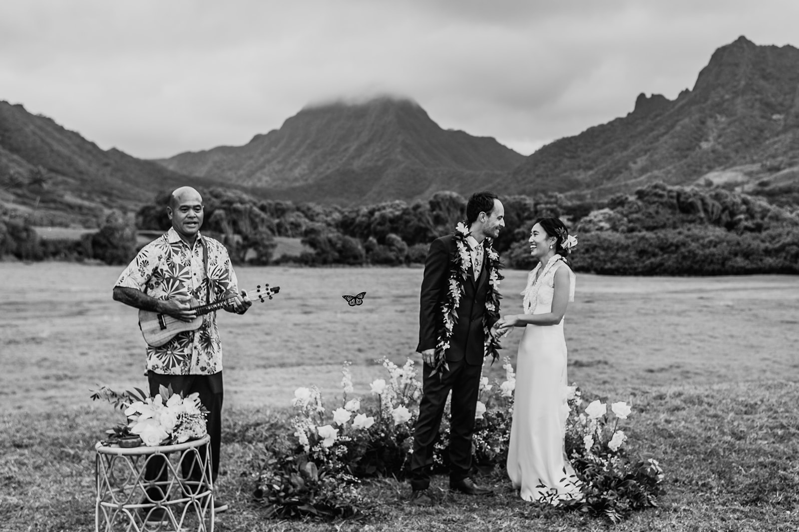 Joyous laughter between the bride and groom during the ceremony as a ukulele player serenades the couple in true Hawaiian style L Hewitt Photography