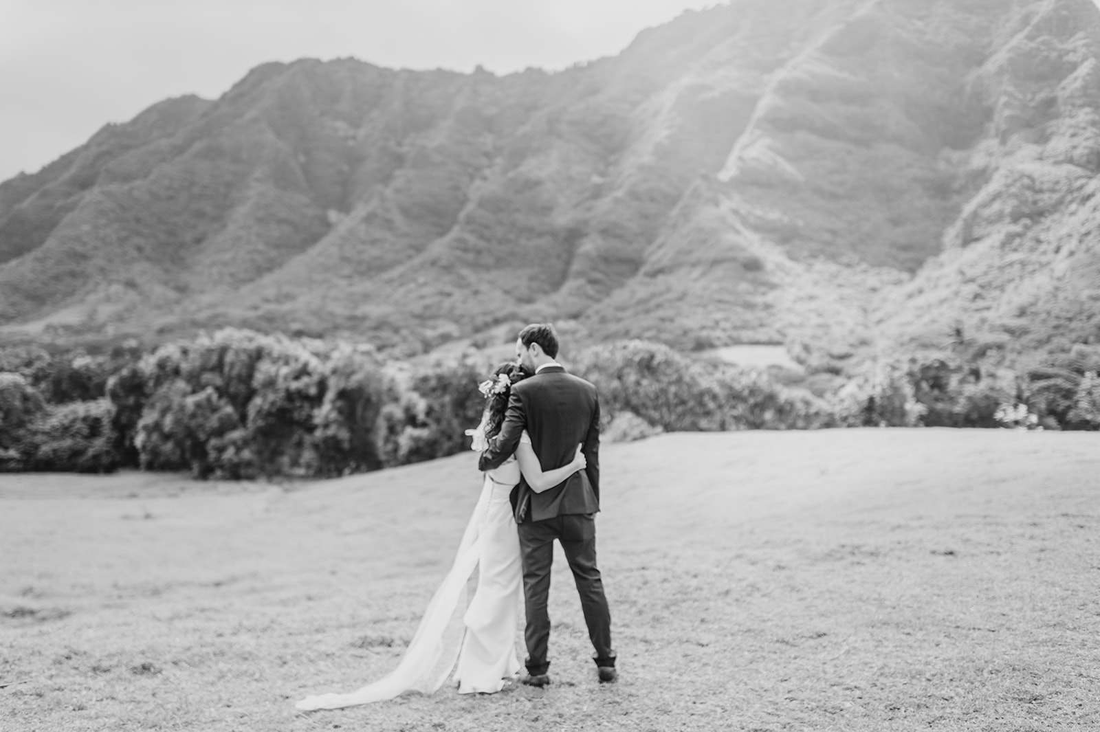 A tender embrace between the bride and groom against the backdrop of majestic mountains L Hewitt Photography