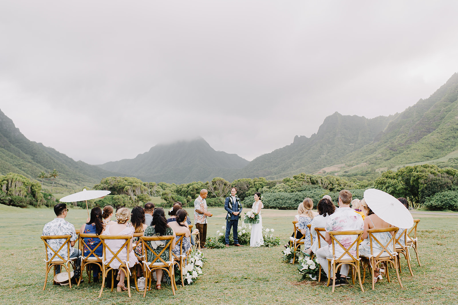 Emotional exchange of vows, creating a memorable moment witnessed by their cherished guests at Kualoa Ranch L Hewitt Photography