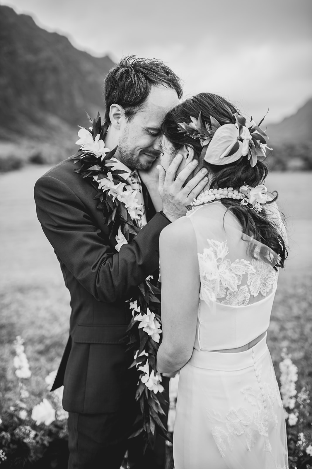 The couple shares a romantic moment, enveloped in the natural beauty of their surroundings of Kualoa Ranch L Hewitt Photography