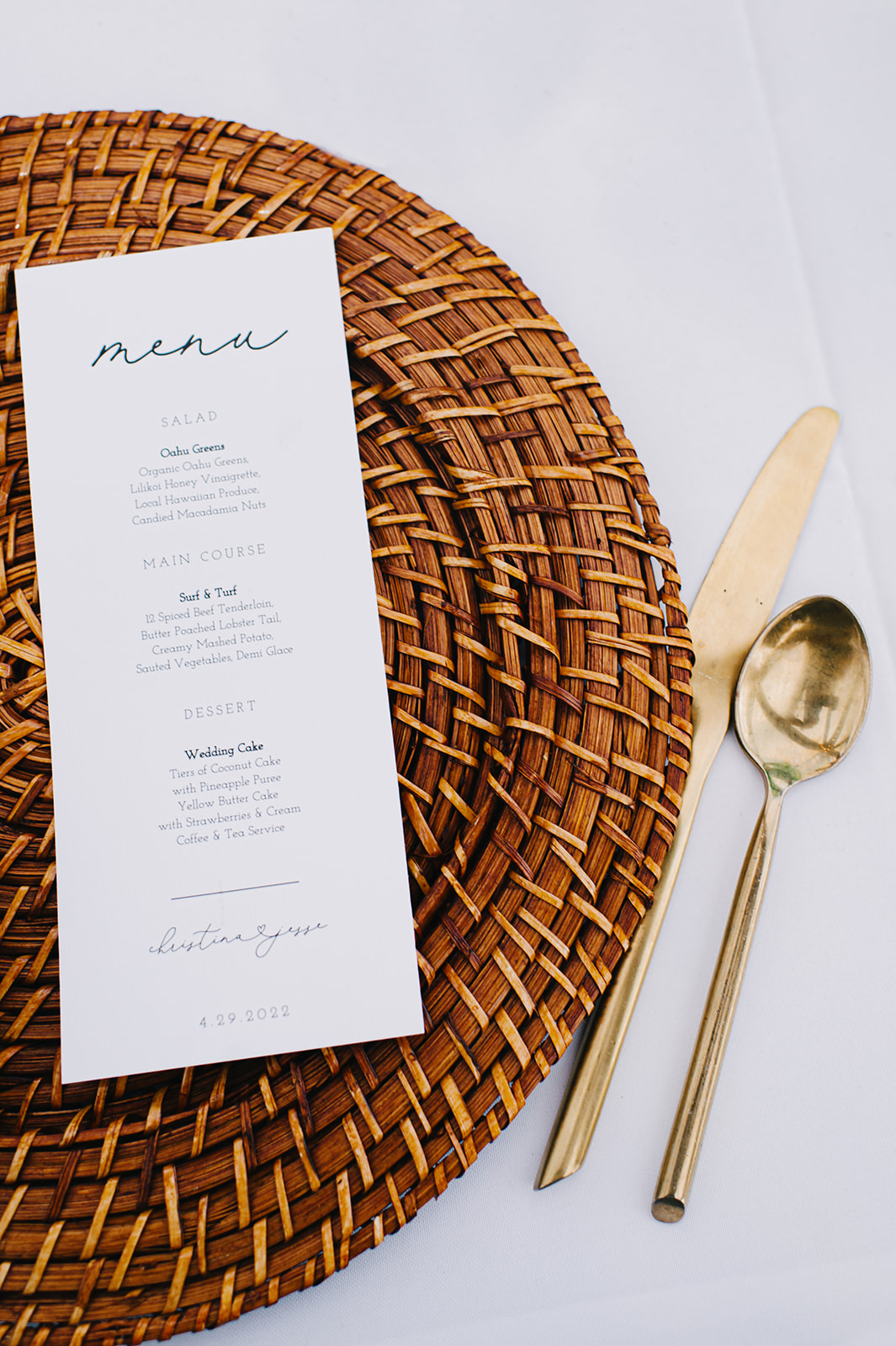 Stylish presentation of the tropical-themed menu, featuring rattan placemats and golden utensils L Hewitt Photography