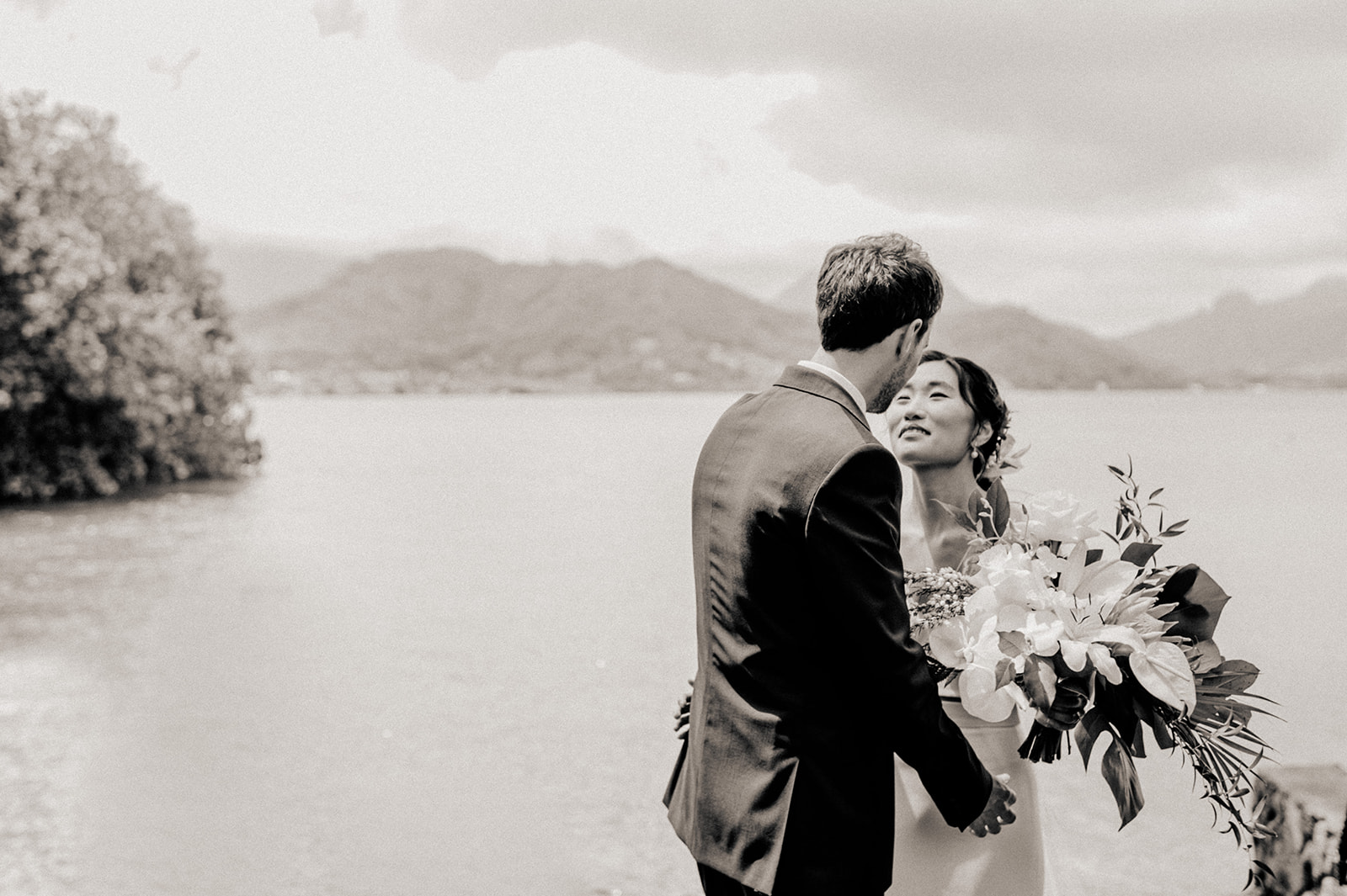 Enchanting scene as the couple shares a romantic moment against the stunning backdrop of sea and mountains L Hewitt Photography