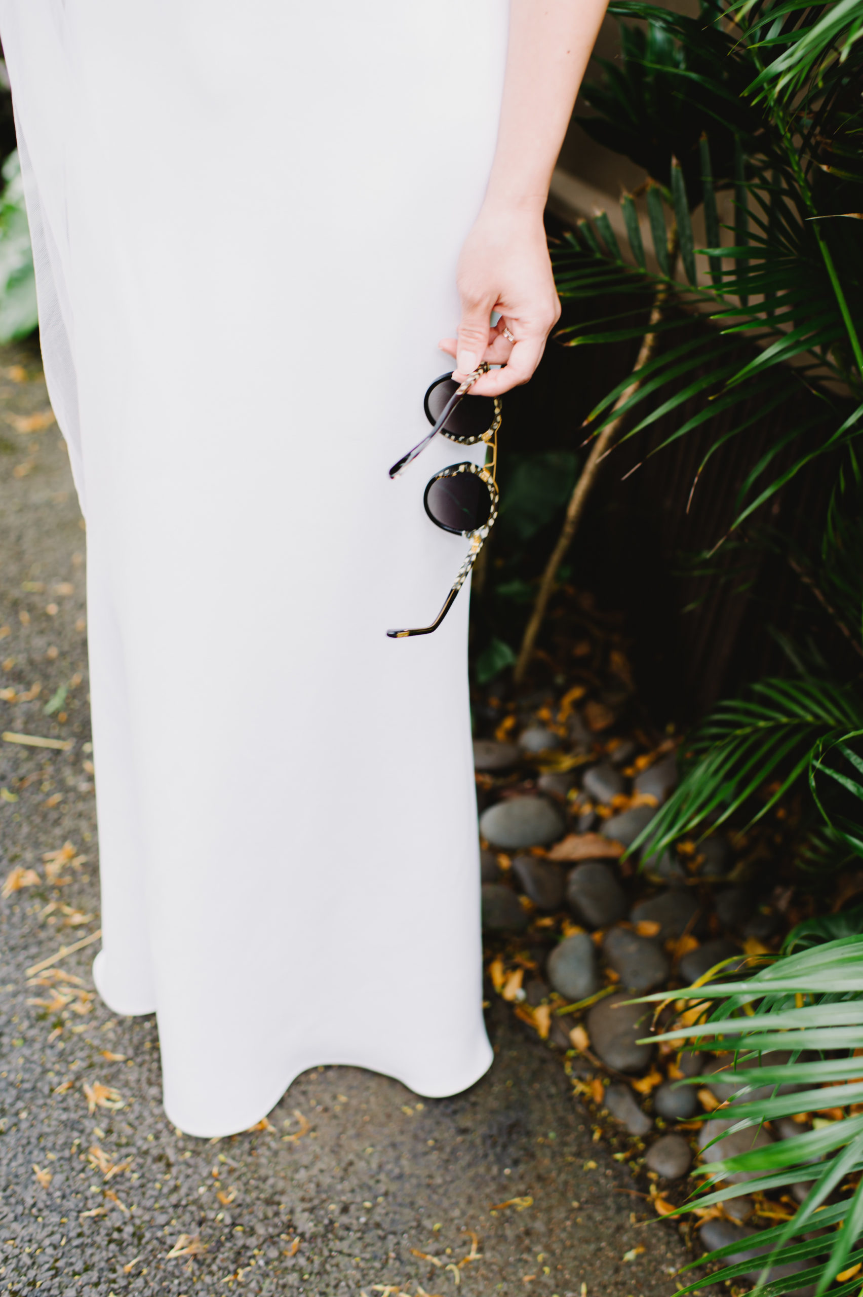 Bride holding chic black and gold sunglasses L Hewitt Photography