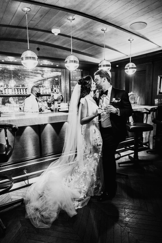 Bride and groom kissing at the whiskey bar.