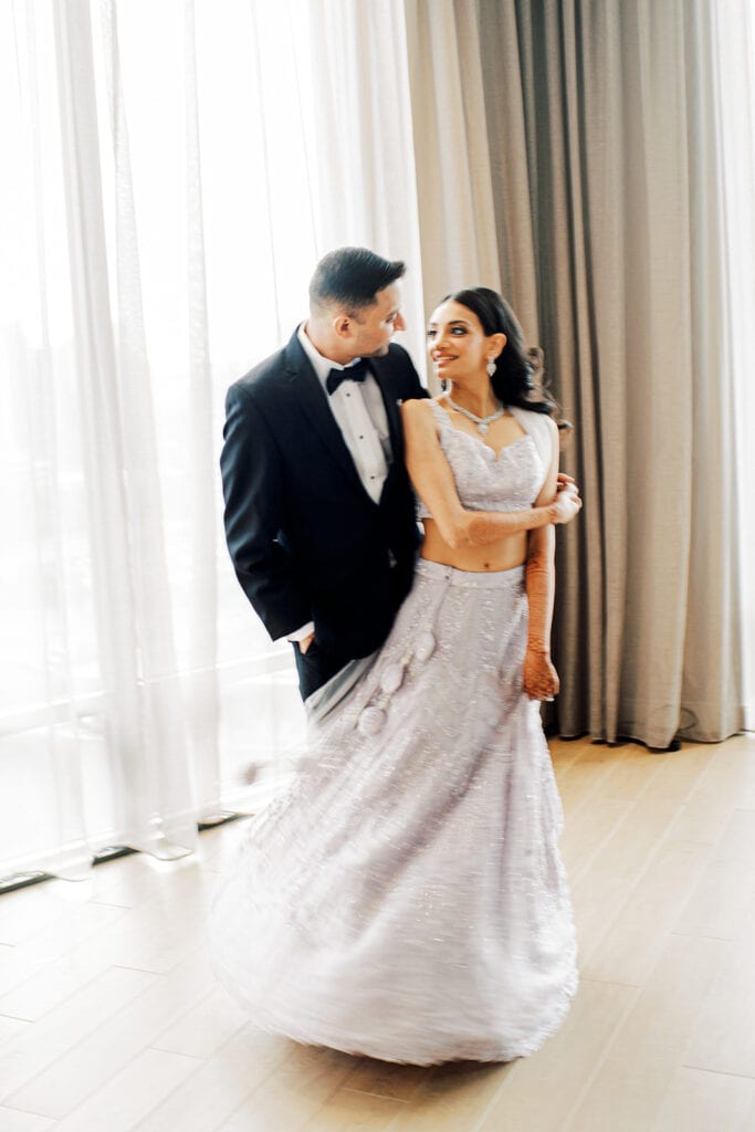 classic portraits of the bride and groom dancing where bride is wearing her lavender silk lehenga as the groom dons a classic tuxedo for their Indian wedding reception at Capital One Hall. L Hewitt Photography
