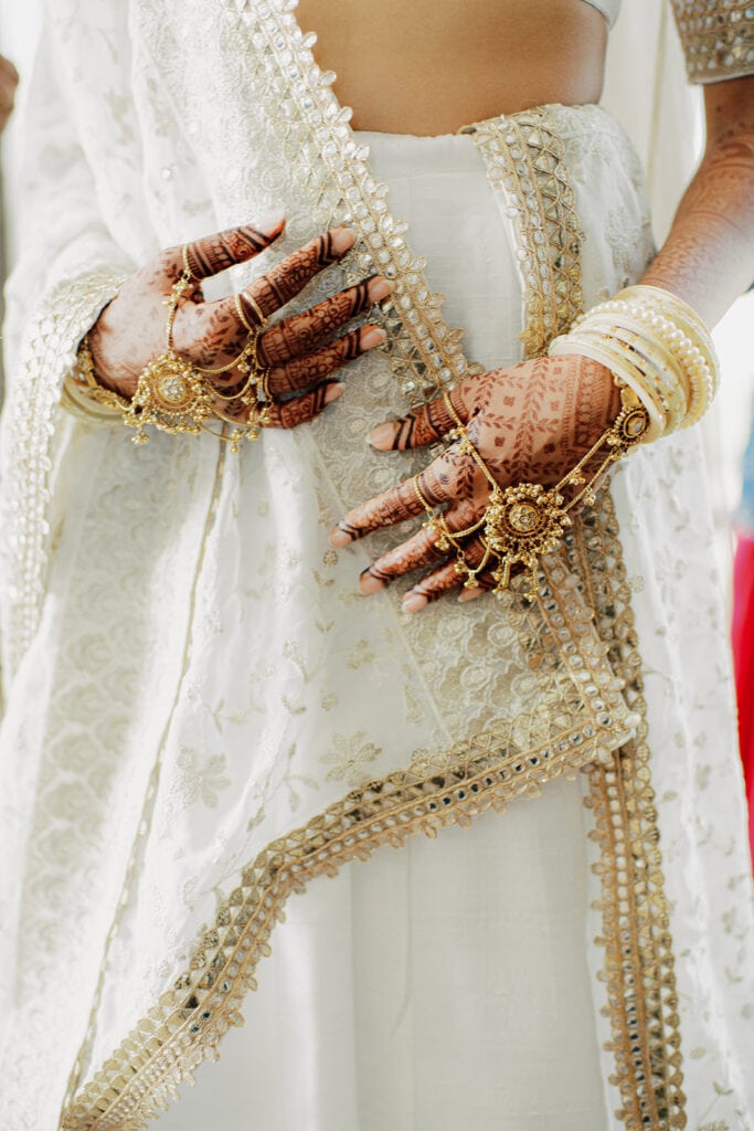 beautiful wedding bridal henna  as she wears her white ang gold lehenga for her Indian wedding ceremony at Capital One Hall. L Hewitt Photography