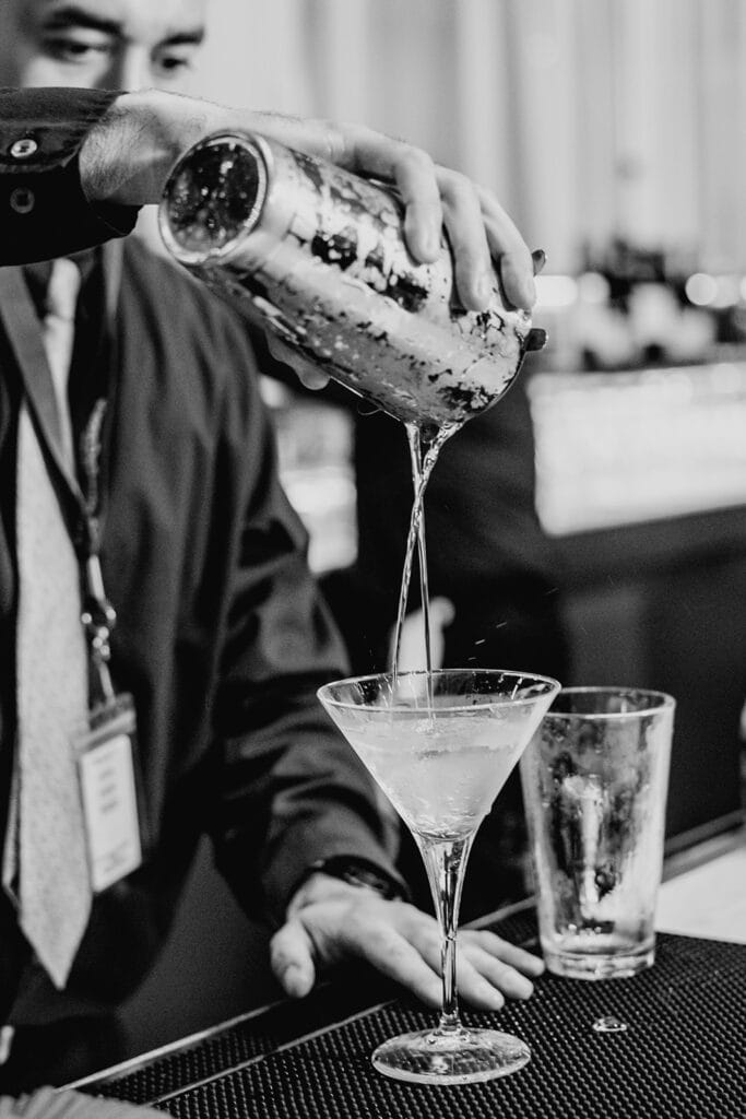bartender mixing drinks at the Indian wedding reception at Capital One Hall. L Hewitt Photography