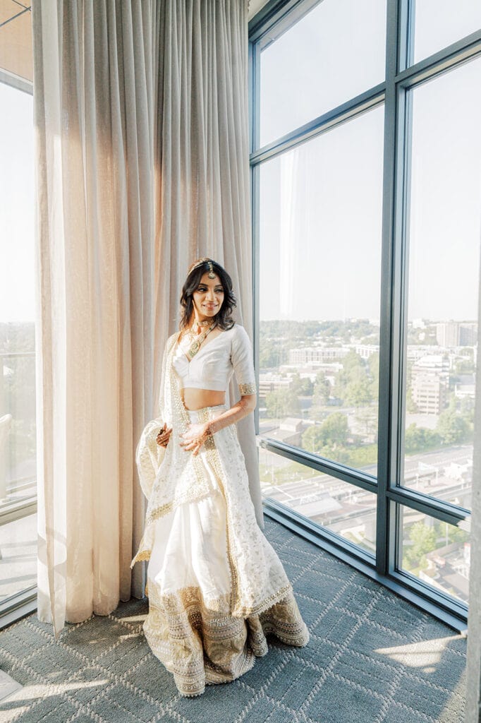 beautiful bride getting ready for her Indian wedding ceremony wearing a white silver silk lehenga at Capital One Hall. L Hewitt Photography