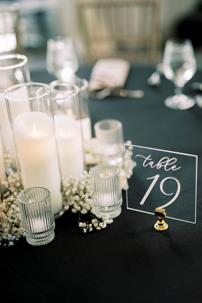 Elegant table number design with candles and baby's breath for Indian wedding reception design by S W Events at Capital One Hall. L Hewitt Photography