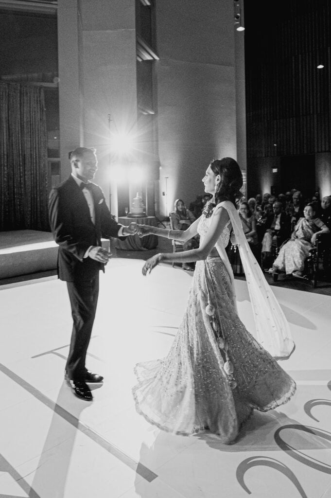 first dance of the bride wearing lilac lehenga with the groom wearing a classic tuxedo at their Indian wedding reception at Capital One Hall. L Hewitt Photography