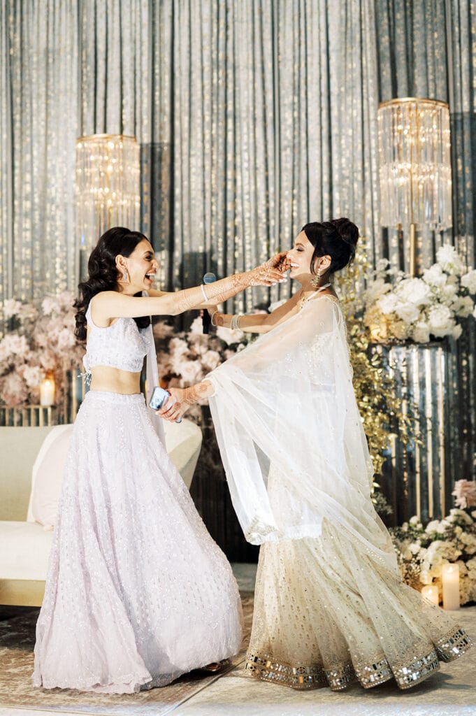 bride wearing lilac lehenga hugs her maid of honor and sister after a speech at an Indian wedding reception at Capital One Hall. L Hewitt Photography